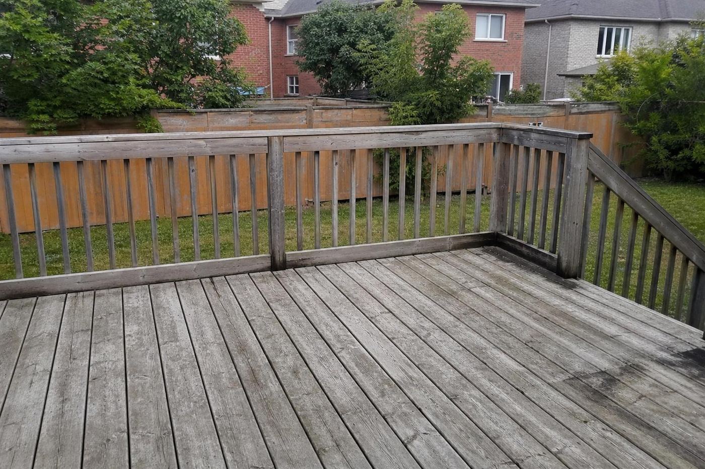 Grey weathered backyard deck before pressure washing
